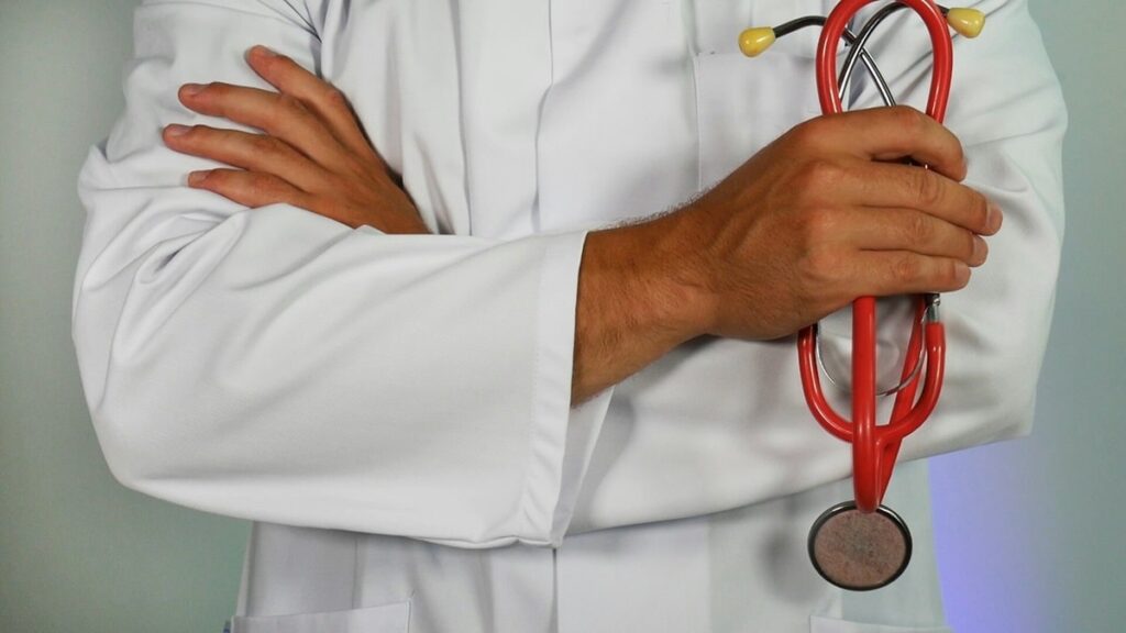 Doctor holding red stethoscope.